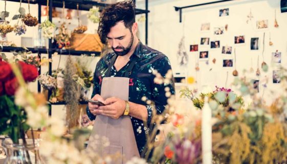 un commerçant fleuriste envoi un sms à ses clients